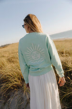 Lade dir das Bild in den Galerie-Viewer, Sweater Unisex Türkis mit weißer Sonne
