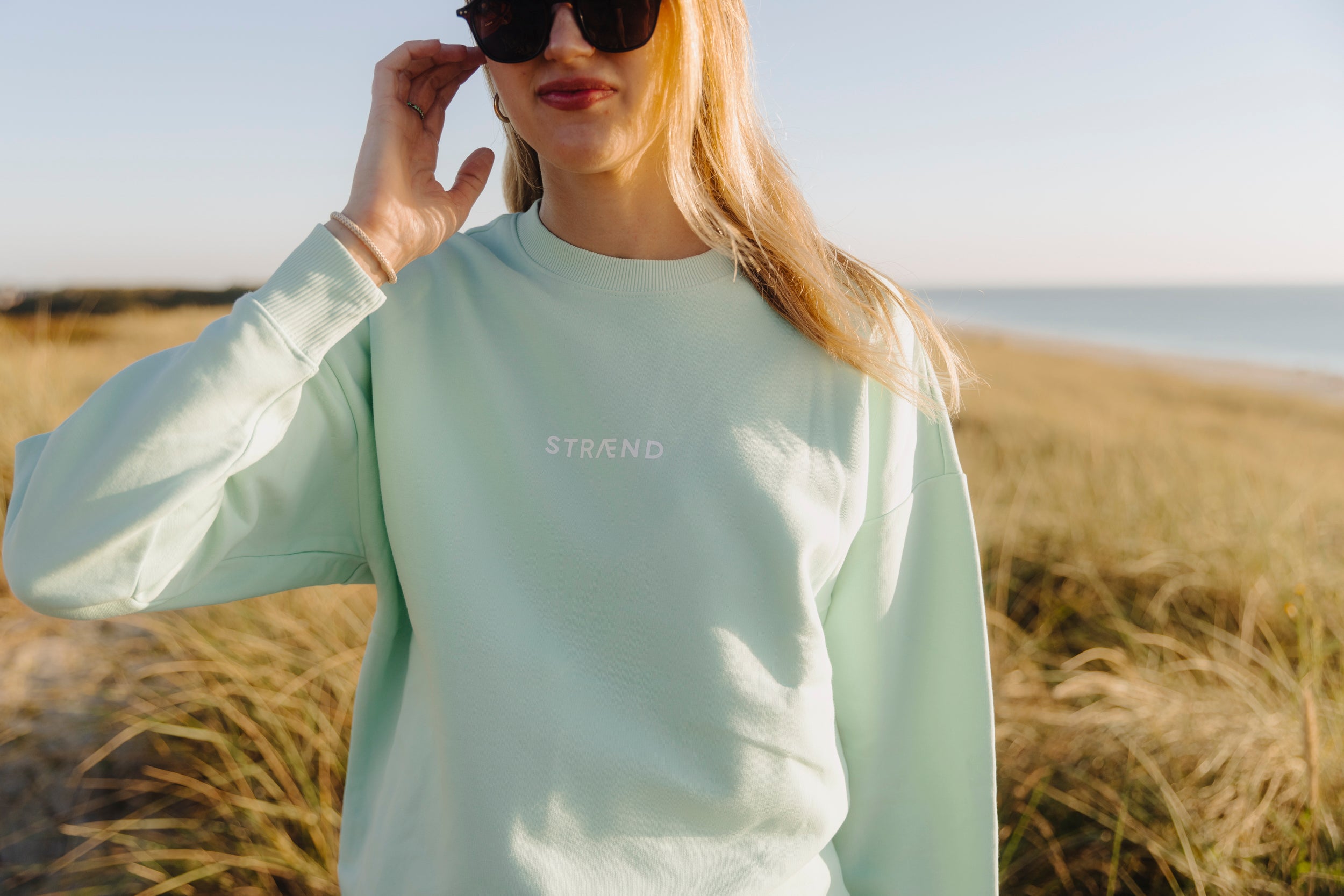 Sweater Unisex Türkis mit weißer Sonne